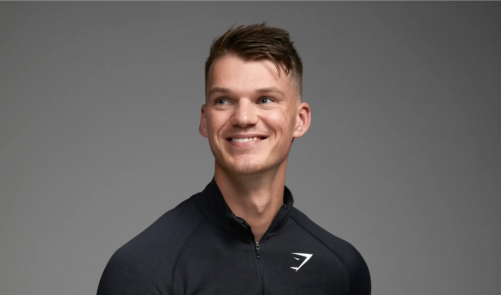 Gymshark CEO Ben Francis smiling in their branded fitness apparel.