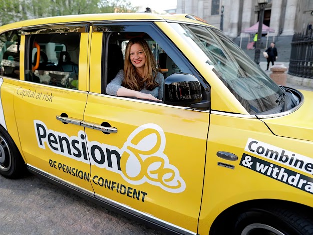 Woman riding in the passenger seat of a taxi that has PensionBee advertising on the side of the car.