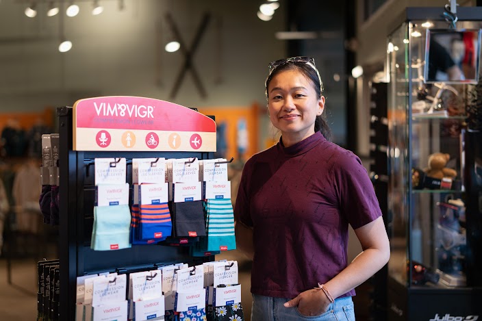 VIM & VIGR owner poses by a rack of socks.