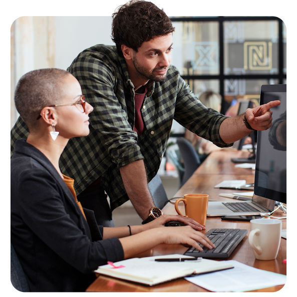 A team of colleagues gathered around a office huddle space.