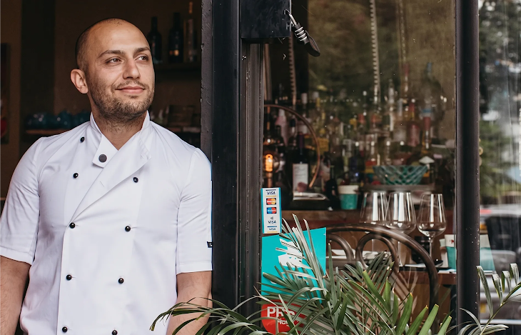 A chef at Belgrave Restaurant looks out of the door into the London neighborhood.